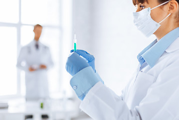 Image showing female doctor holding syringe with injection