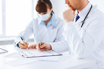 Image showing doctor and nurse writing prescription paper