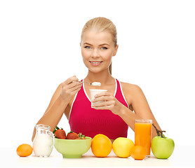 Image showing young woman eating healthy breakfast