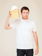 Image showing man in white t-shirt with gift box