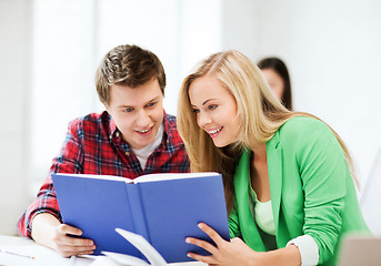 Image showing girl and guy reading book at school