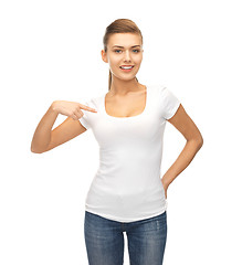 Image showing smiling woman pointing at blank white t-shirt