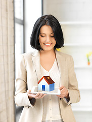 Image showing woman holding tablet pc with house illustration