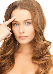 Image showing beautiful woman pointing at her forehead