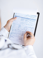 Image showing male doctor holding prescription paper in hand