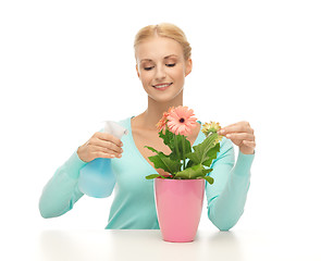 Image showing woman holding pot with flower and spray bottle