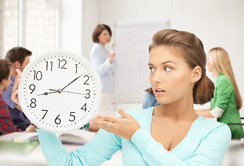 Image showing girl holding big clock at school