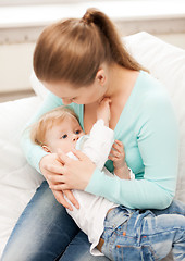 Image showing mother and adorable baby with feeding-bottle