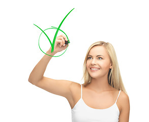 Image showing woman in white shirt drawing green checkmark