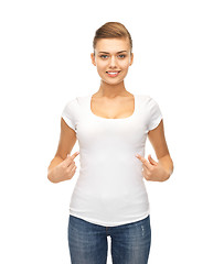 Image showing smiling woman pointing at blank white t-shirt