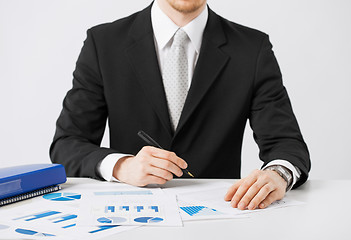 Image showing businessman working and signing with papers