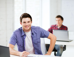 Image showing smiling student with laptop at school