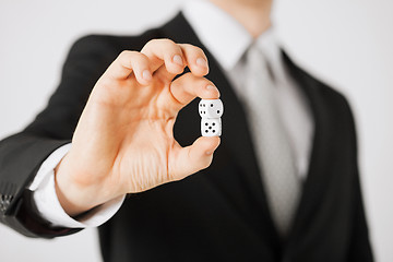 Image showing mans hand holding white casino dice