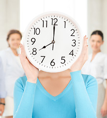 Image showing businesswoman with clock over her face