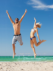 Image showing couple jumping on the beach