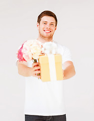 Image showing man holding bouquet of flowers and gift box