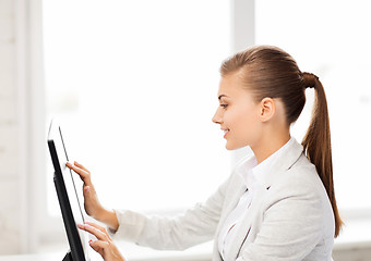 Image showing smiling businesswoman with touchscreen in office