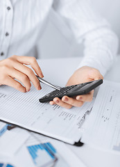 Image showing woman hand with calculator and papers