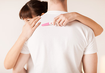 Image showing woman with pregnancy test hugging man