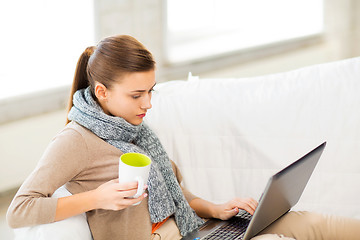 Image showing diseased woman in scarf using laptop at home