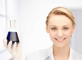 Image showing female chemist holding bulb with chemicals