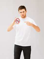 Image showing young man pointing at no smoking sign