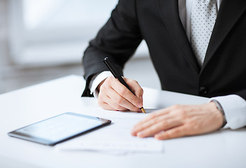 Image showing man with tablet pc signing paper