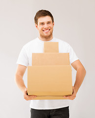 Image showing smiling man carrying carton boxes