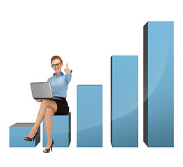 Image showing businesswoman sitting on big 3d chart