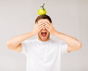 Image showing man with green apple on his head