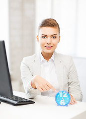 Image showing attractive businesswoman pointing at clock