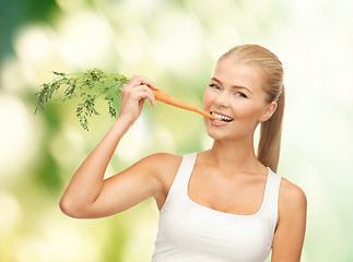 Image showing healthy young woman biting carrot