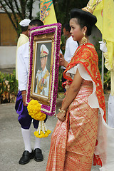 Image showing Thai youth holding a photograph of the King during in a parade,