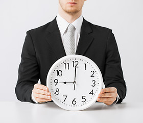 Image showing man with wall clock