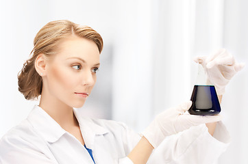 Image showing female chemist holding bulb with chemicals