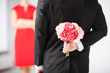 Image showing man hiding bouquet of flowers