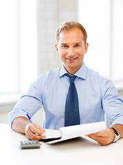 Image showing businessman with notebook and calculator