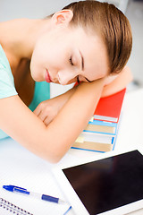 Image showing tired student sleeping on stock of books