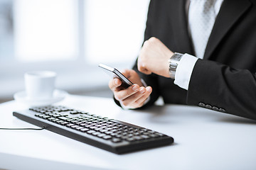 Image showing man hands with keyboard, smartphone and wristwatch