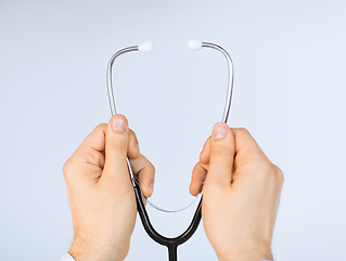 Image showing doctor hand with stethoscope listening something