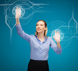 Image showing businesswoman touching virtual screen