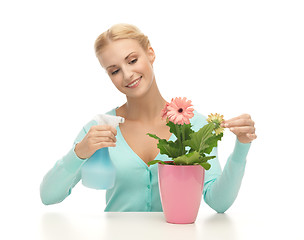 Image showing woman holding pot with flower and spray bottle