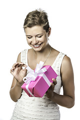 Image showing Young pretty woman unwraps gift