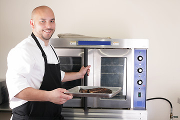 Image showing Happy chef taking his freshly baked rib-eye steak