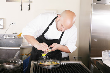 Image showing Chef putting grated parmesan to an italian pasta