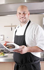 Image showing Chef presenting a juicy steak in the kitchen