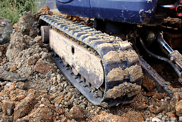 Image showing Digger's tracks on rubble, soil and brick