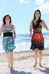 Image showing Two attractive barefoot women on the beach