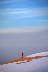 Image showing Hiker on edge of cliff in sunrise