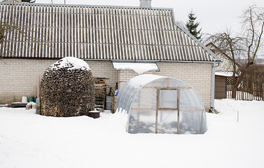 Image showing stack firewood polythene greenhouse snow winter 